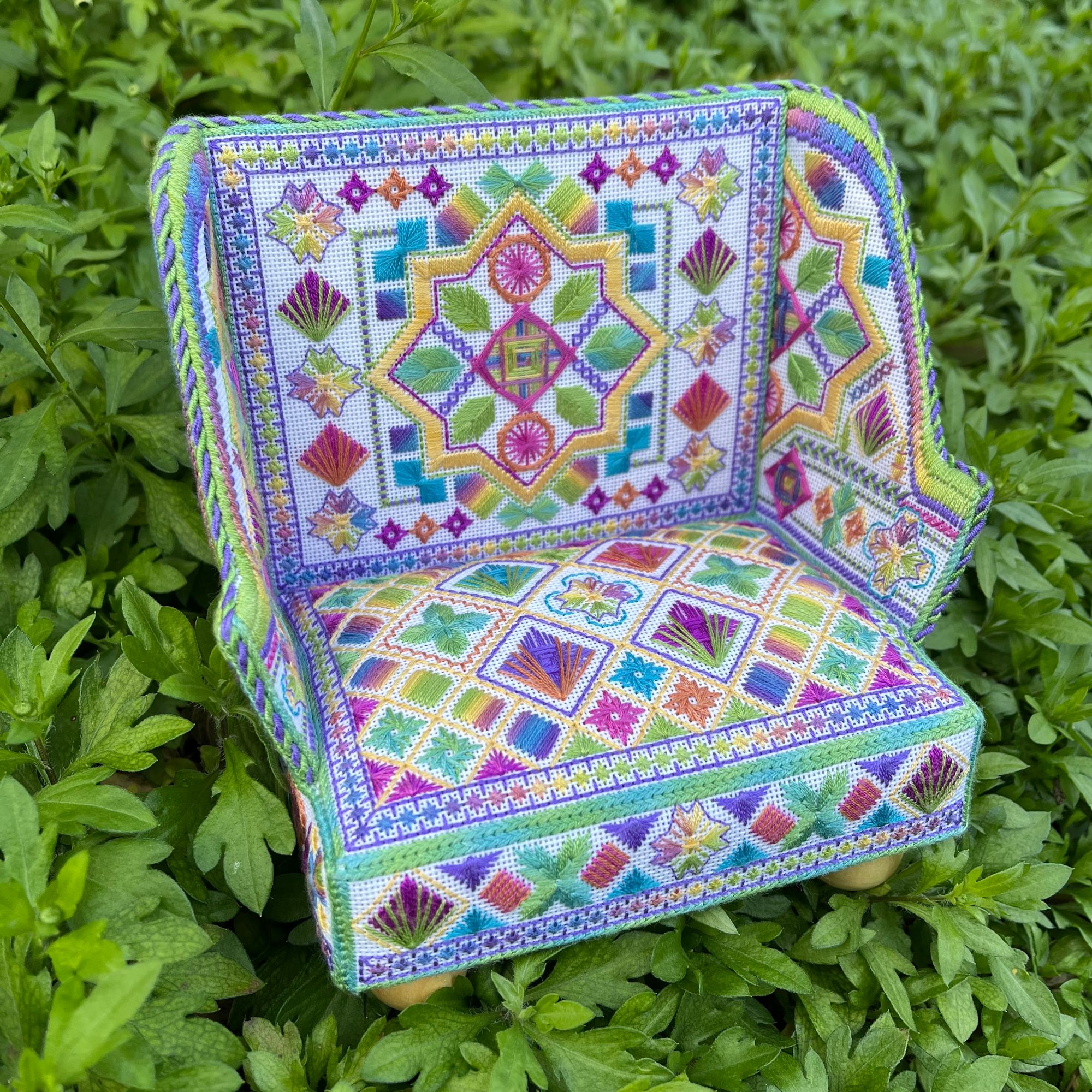 A small model chair, hand embroidered.