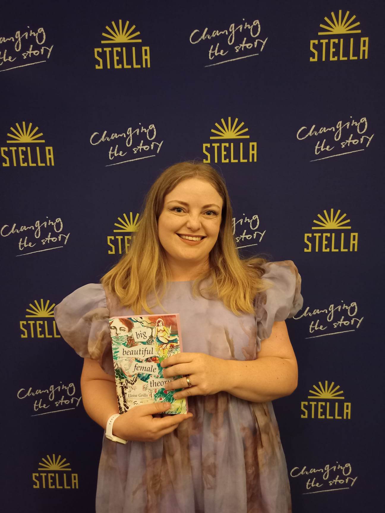 Eloise holding her book, big beautiful female theory, for the Stella Prize photo shoot.