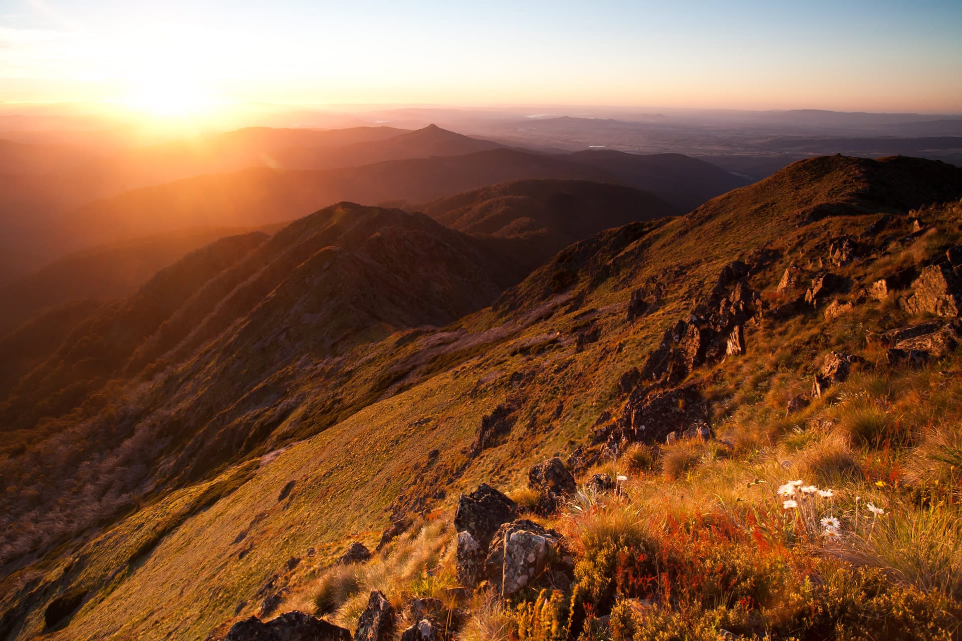 A view over a mountain rang with the sun setting. 