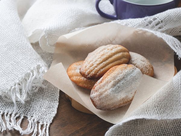 A cup of tea with a plate of madeleines. 